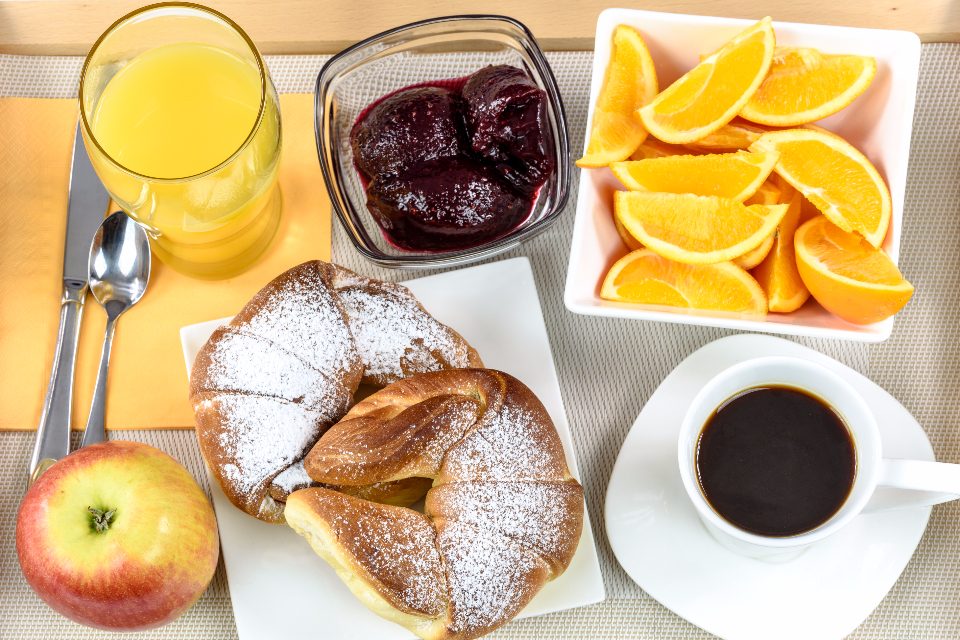 Breakfast spread with coffee, pastries, orange juice and fruit