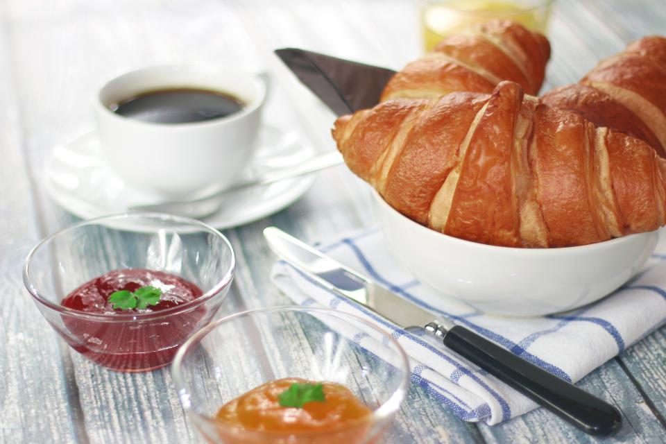 Croissants, coffee and preserves on the breakfast table