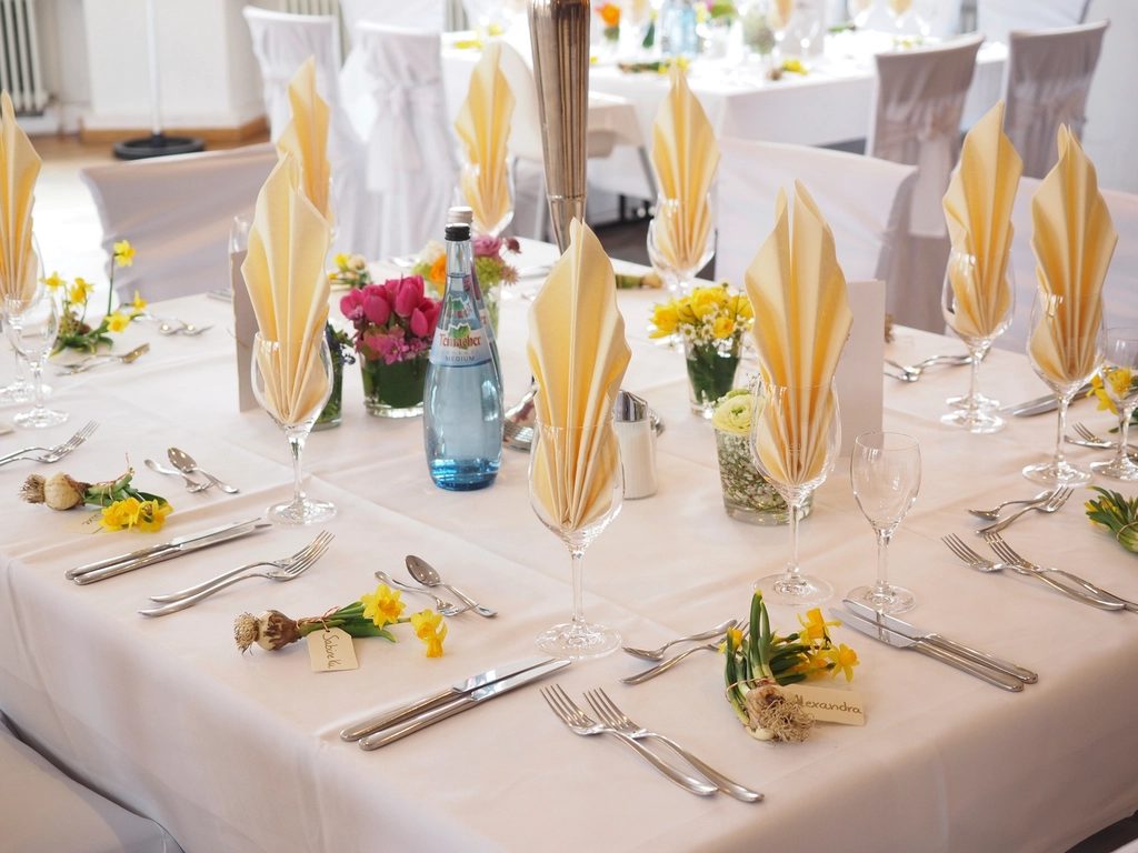 Elegantly set banquet table with linen and fresh flowers
