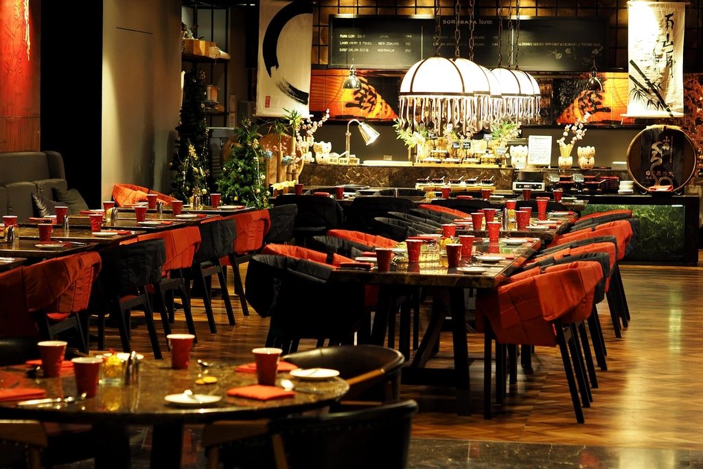 Marigold restaurant in the evening — red velvet chairs and warm pendant light