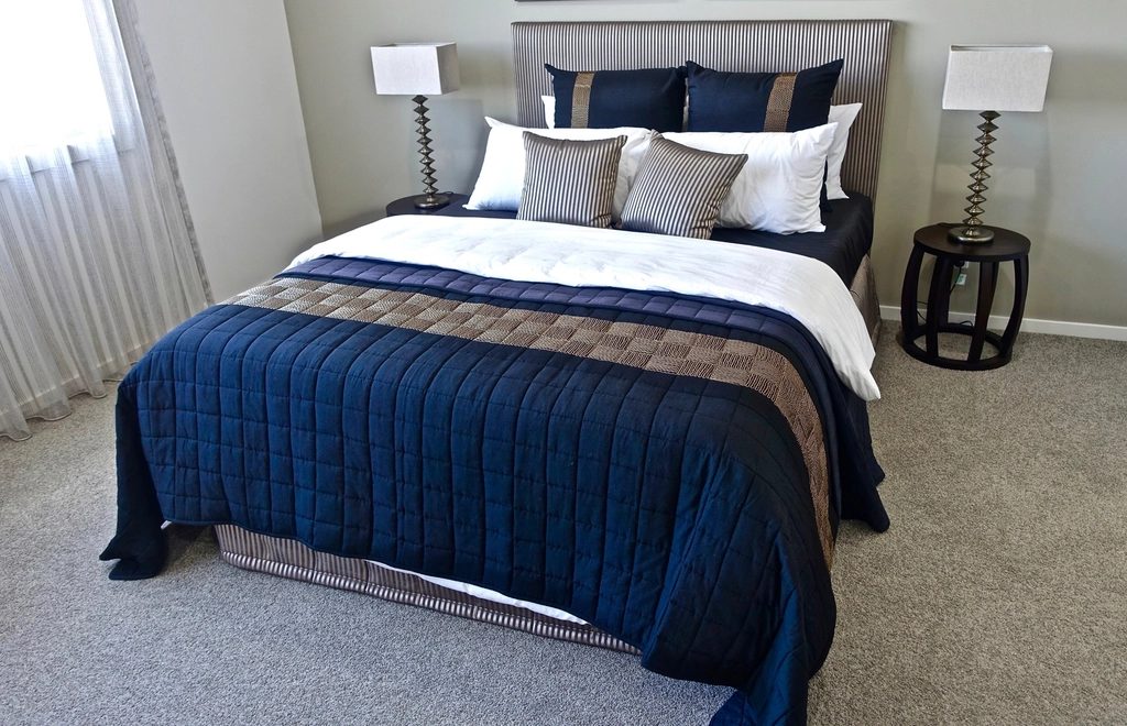 Classic Queen room with a navy quilt and twin bedside lamps