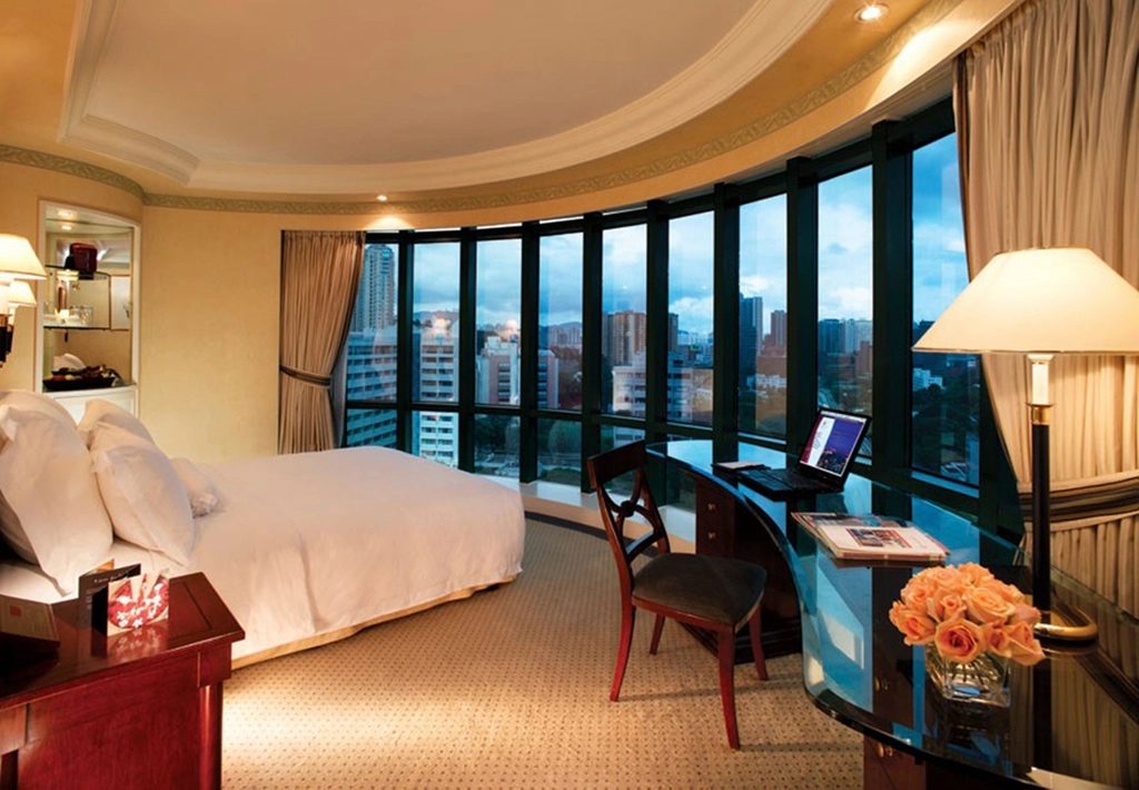 Junior Suite with curved corner windows and a desk with a view