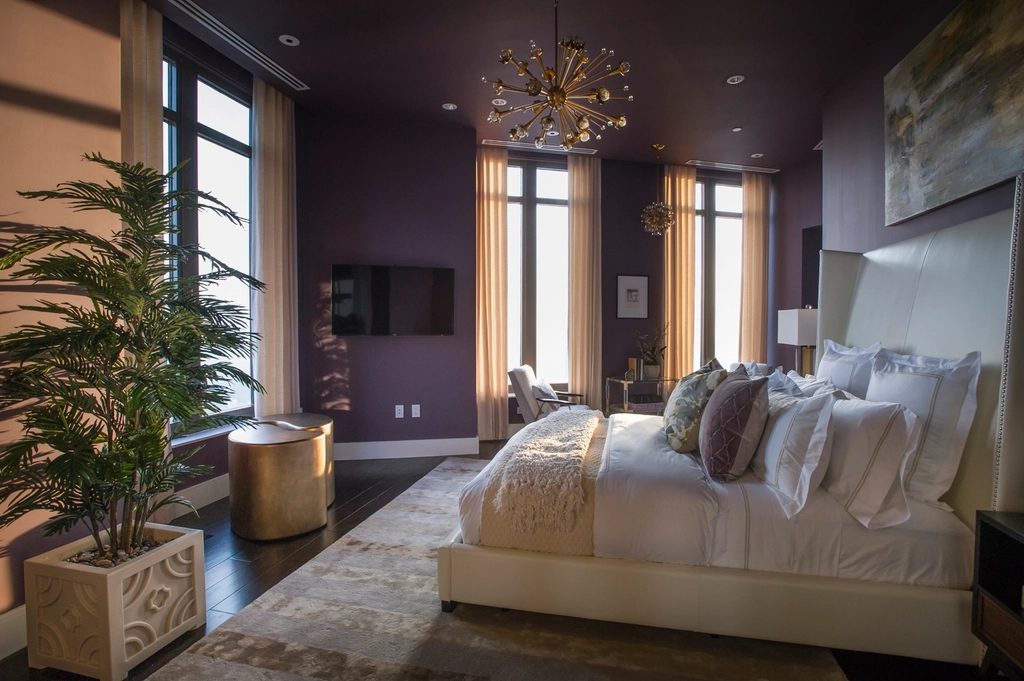 Suite bedroom with tall windows and a chandelier