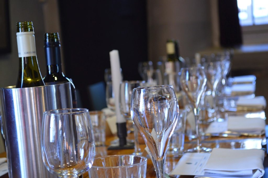 Wine glasses and bottles on a long table in the Wexley Wine Room